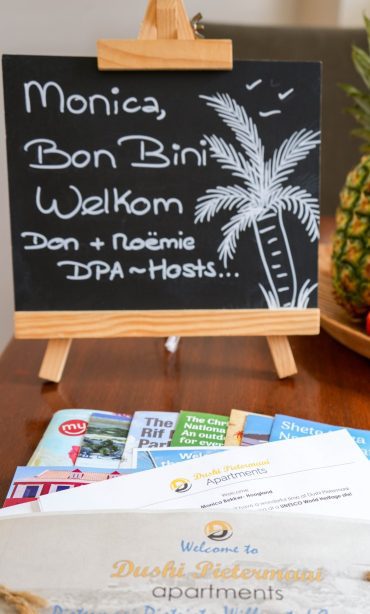 Overview of amenities at Dushi Pietermaai Apartments with welcome board and Curaçao travel guides