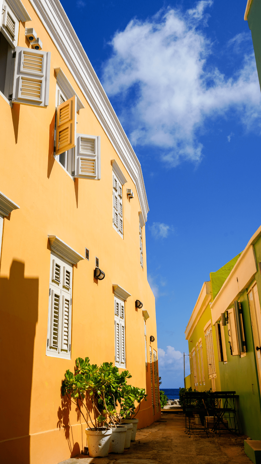Bright yellow Caribbean façade of Dushi Pietermaai Apartments in Pietermaai District, Curaçao