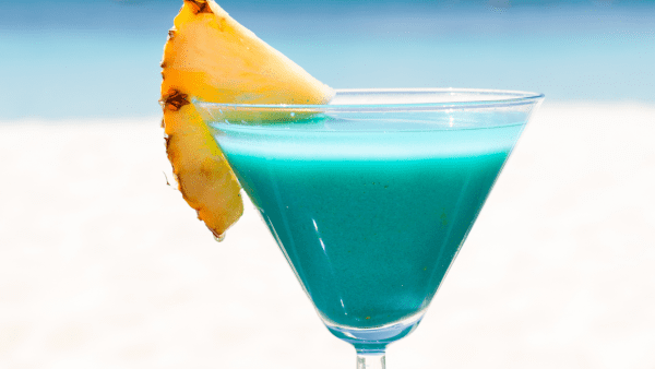 Tropical cocktail with pineapple on a beach bar table – Curaçao
