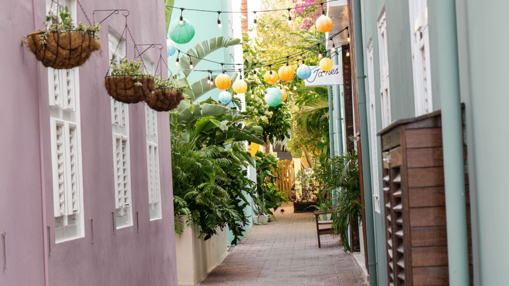 Colourful alleyway in Pietermaai District with hanging plants and pastel buildings in Curaçao