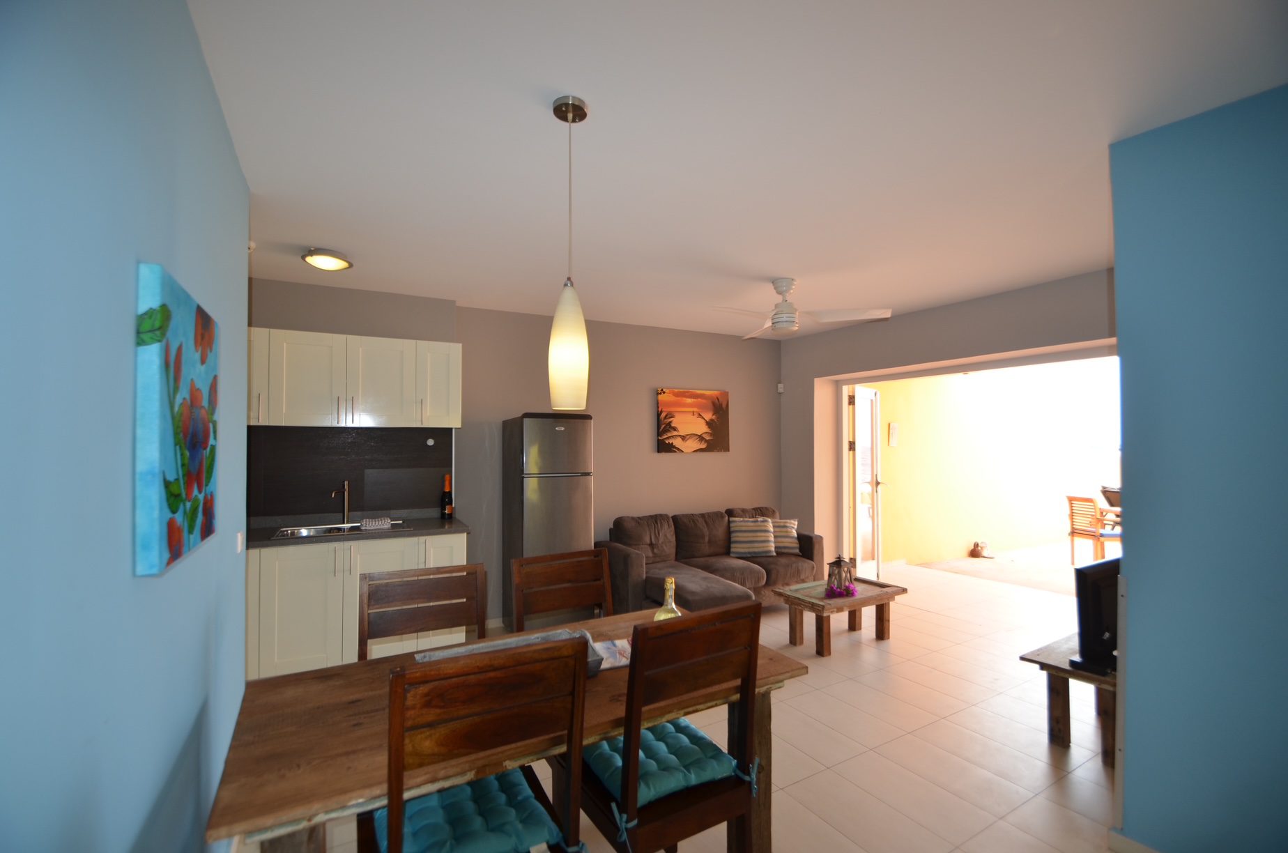 Open-plan living space with patio access in Luna apartment, Dushi Pietermaai, Curacao