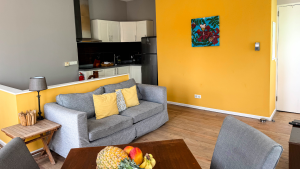 Urban-style apartment Tierra with yellow accent wall and modern living area – Dushi Pietermaai Apartments