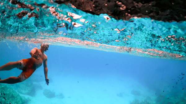 Snorkeler in clear turquoise water with tropical fish – Curaçao