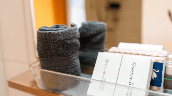 Rolled towels and welcome card at Dushi Pietermaai Apartments in Curaçao, representing house rules and guest amenities