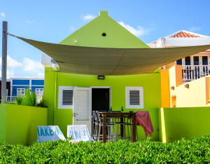 Front view of Aqua apartment with green facade and private patio – Dushi Pietermaai Apartments