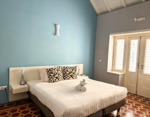 Spacious master bedroom with blue wall and double bed – Aqua apartment Curaçao