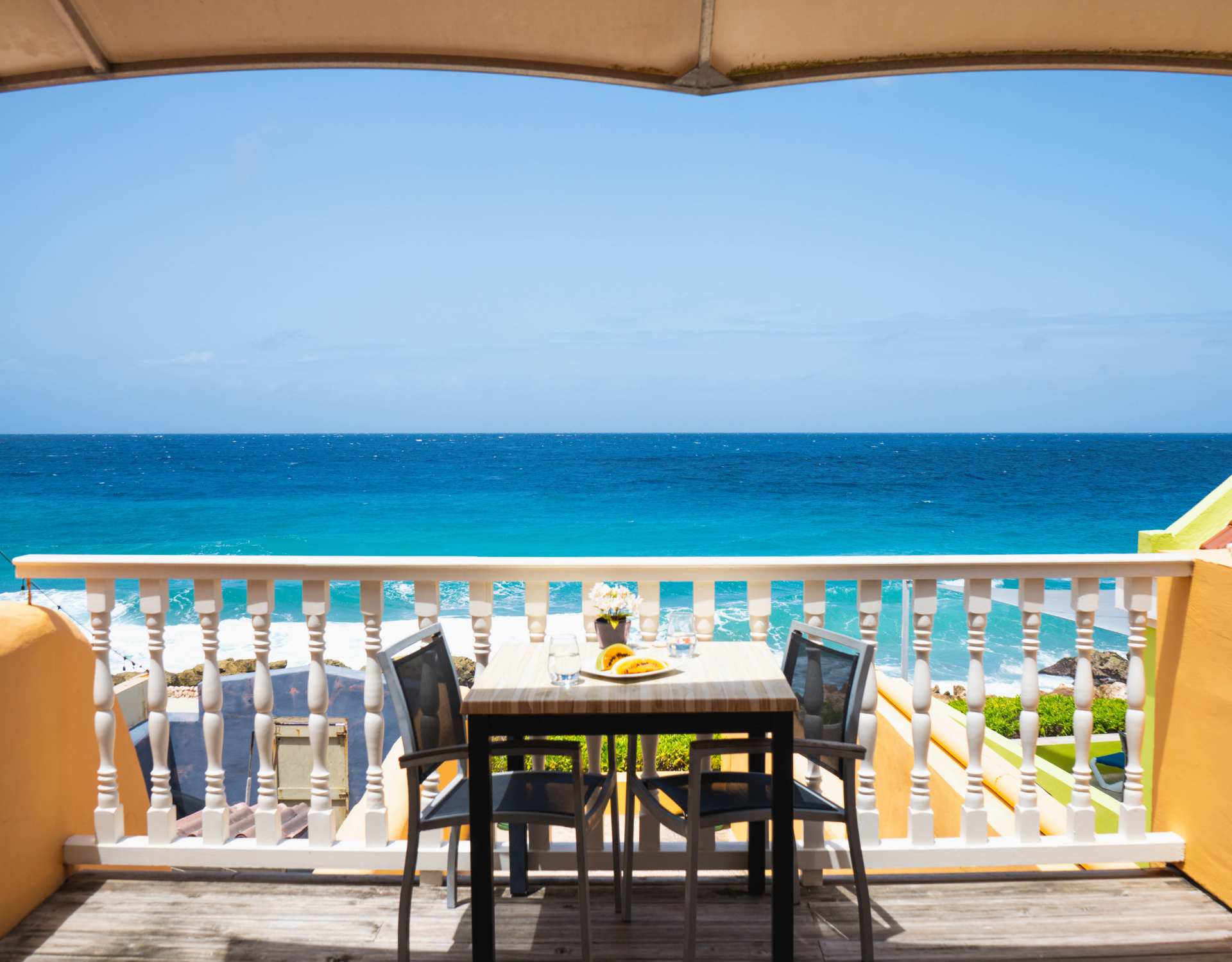 Sea view balcony with table and chairs in colourful district