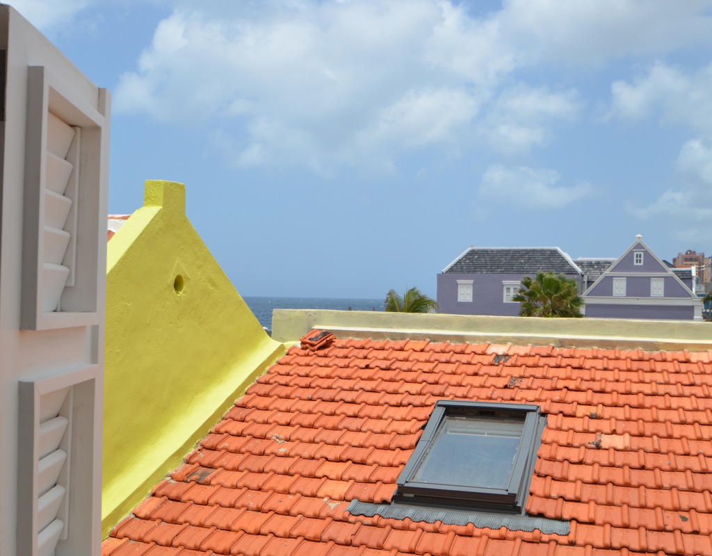 View over red rooftops towards the Caribbean Sea – Tierra apartment Curaçao